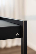 Detailaufnahme des Schreibtisch DONNA mit elegantem schwarzem Finish und modernen Kanten.