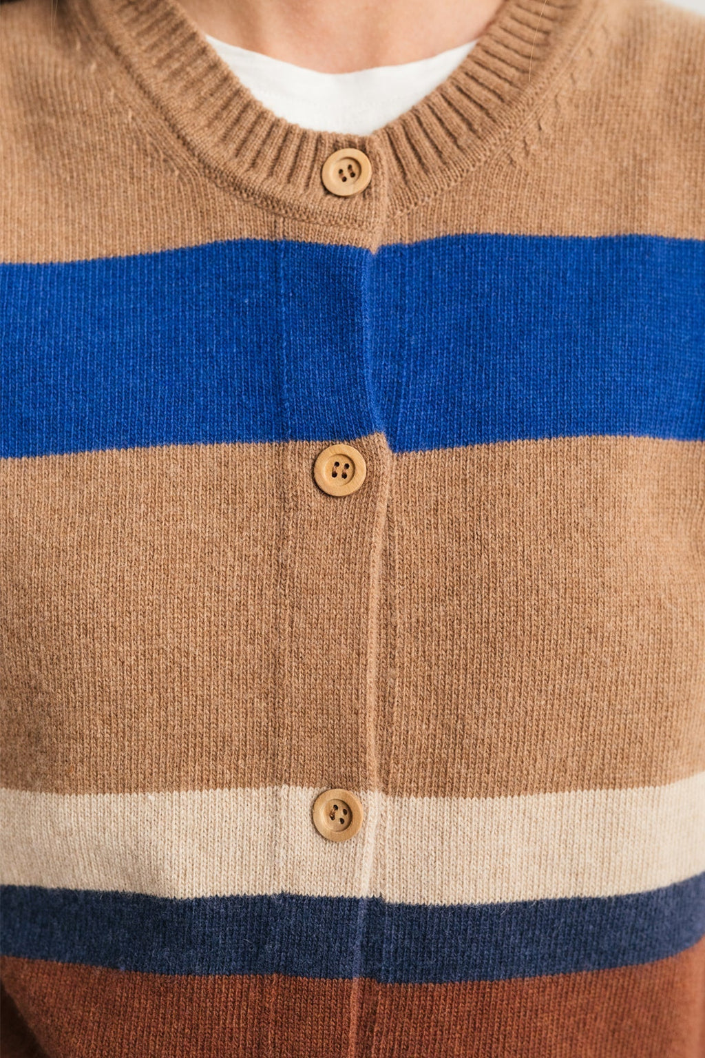 close-up of eco-conscious striped vest with natural wood buttons