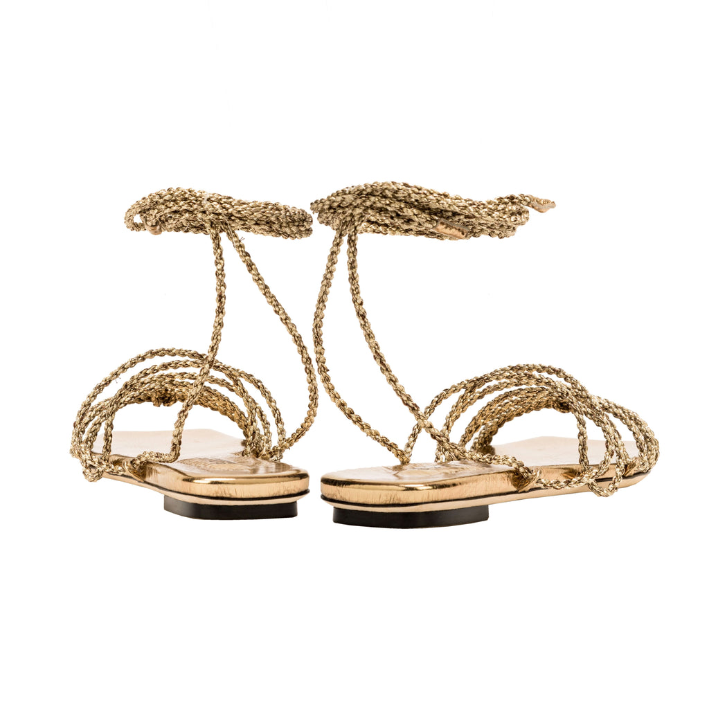 Elegant antique gold Ophilia lace-up sandals featuring braided straps designed to be worn loose or tight.