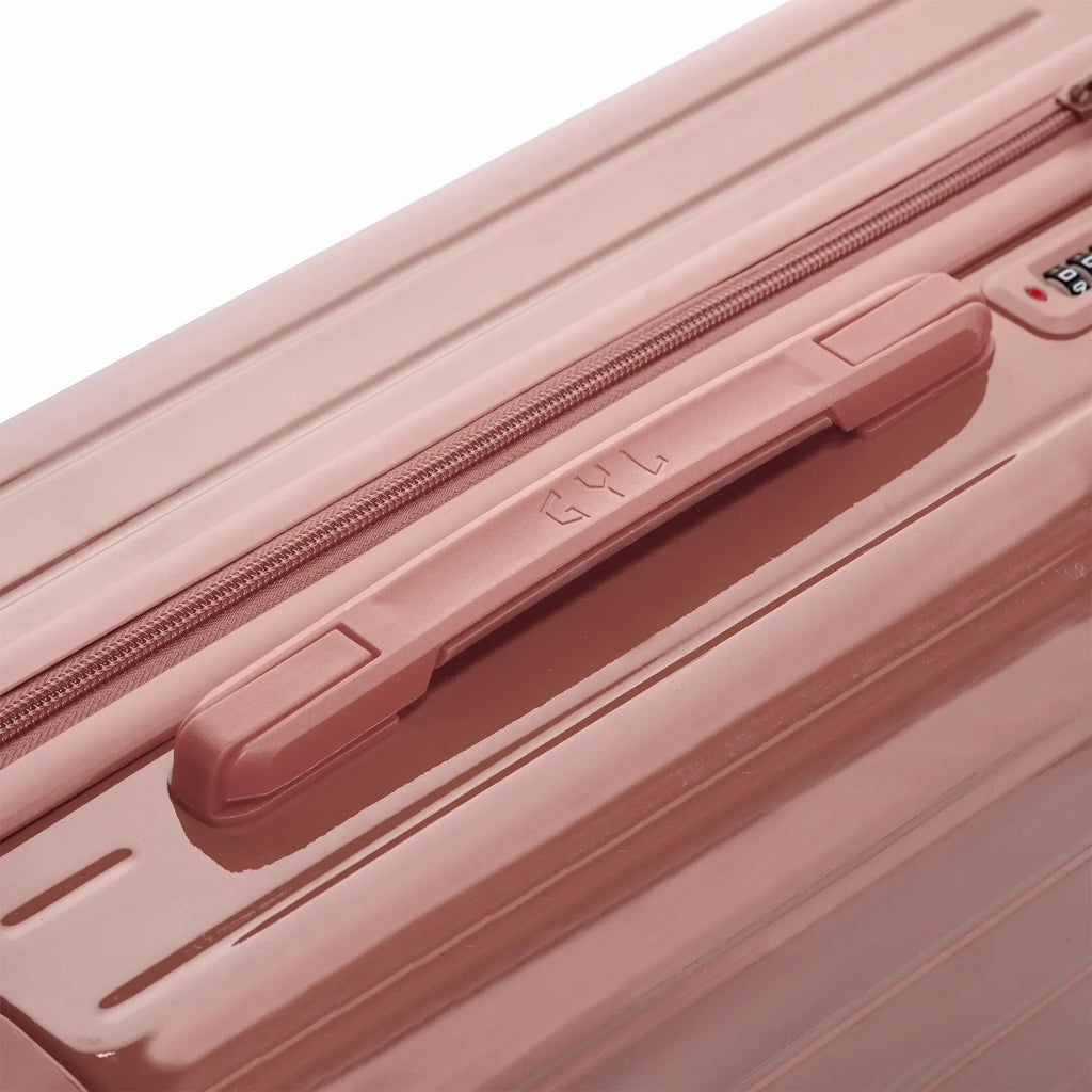 Poignée supérieure rigide de la valise GYL Intemporelle rose gold avec logo embossé sur le dessus. #couleur_rose gold