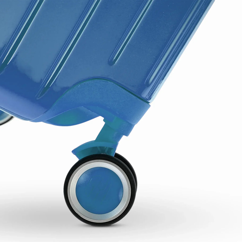 Roue double 360° de la valise GYL Intemporelle bleu grisé avec gravure du logo GYL sur le moyeu. #couleur_bleu grisé