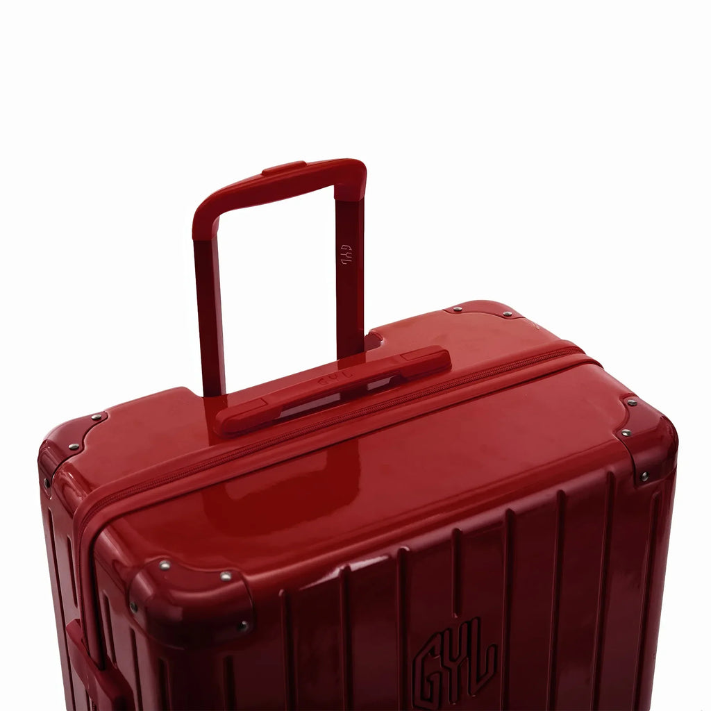 Poignée trolley télescopique GYL déployée sur la valise Intemporelle rouge foncé en polycarbonate. #couleur_rouge foncé